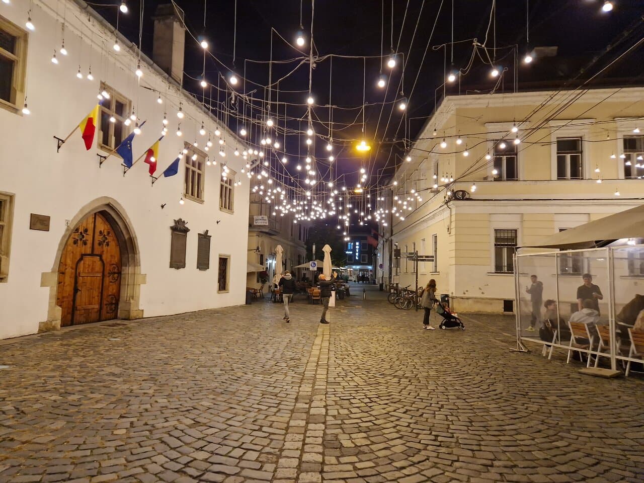 Strada pietonală din centrul vechi Cluj, noaptea, cu bănci și clădiri vechi