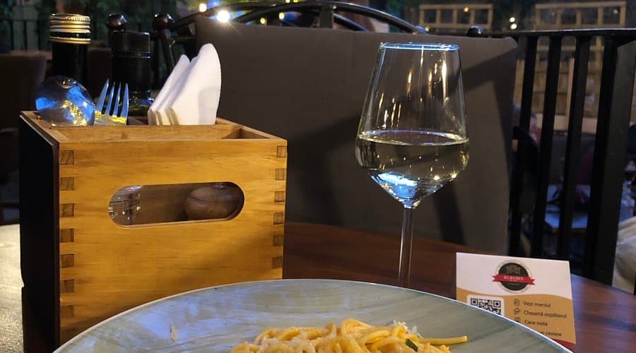 Paste cu pahar de vin alb, servite pe terasă seara