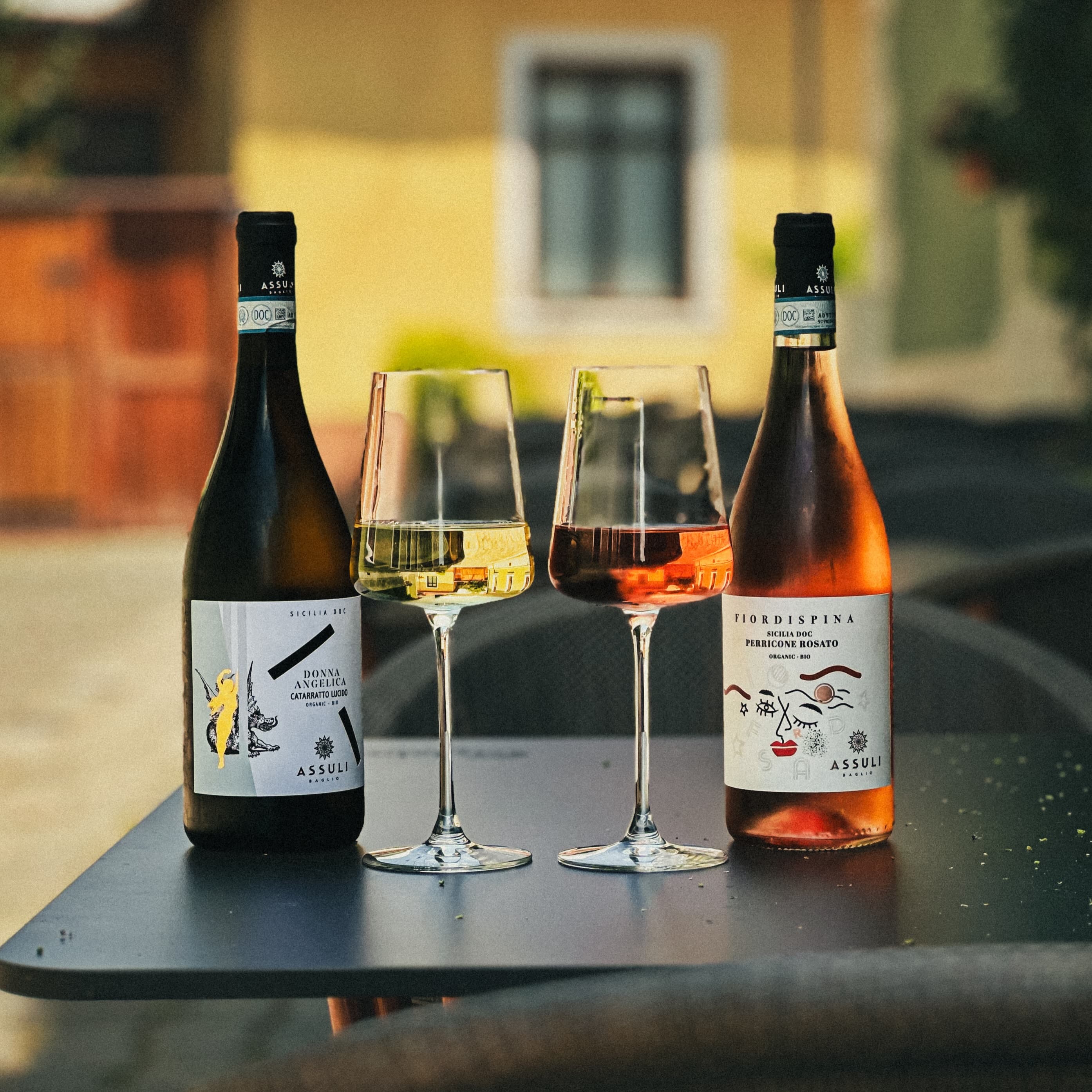 Sticle de vin organic sicilian pe o masă în aer liber